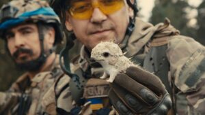 A Ukrainian soldier holds up a tiny sculpture in Porcelain War